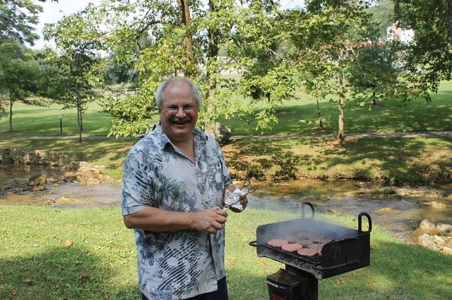 Grill master Carl Bailey with his weapon of choice at the 2012 picnic.